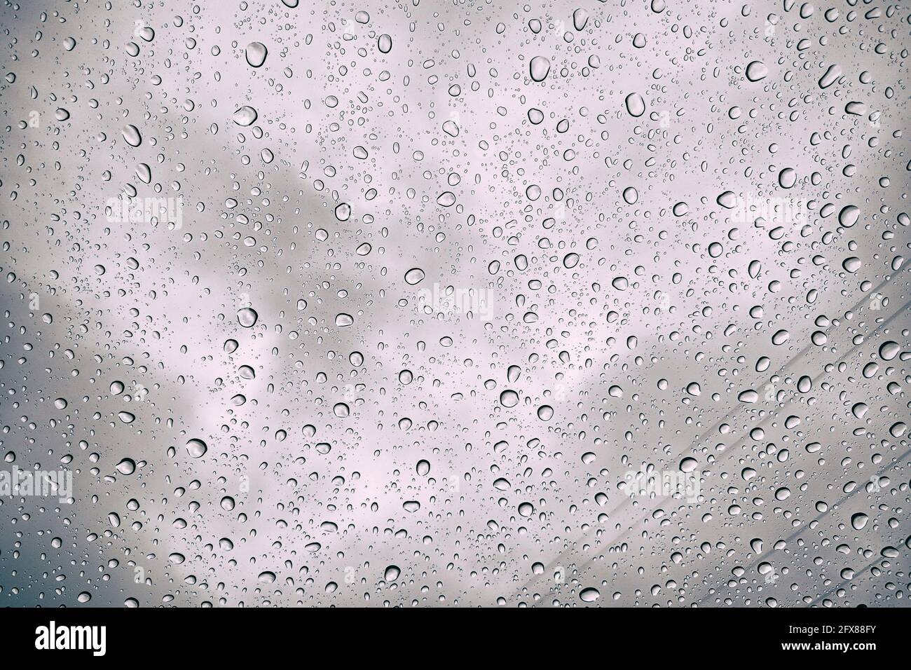 Gocce di pioggia visibili sul finestrino. Pioggia autunnale sul vetro dell'auto, fuoco selettivo sulla pioggia. Foto Stock