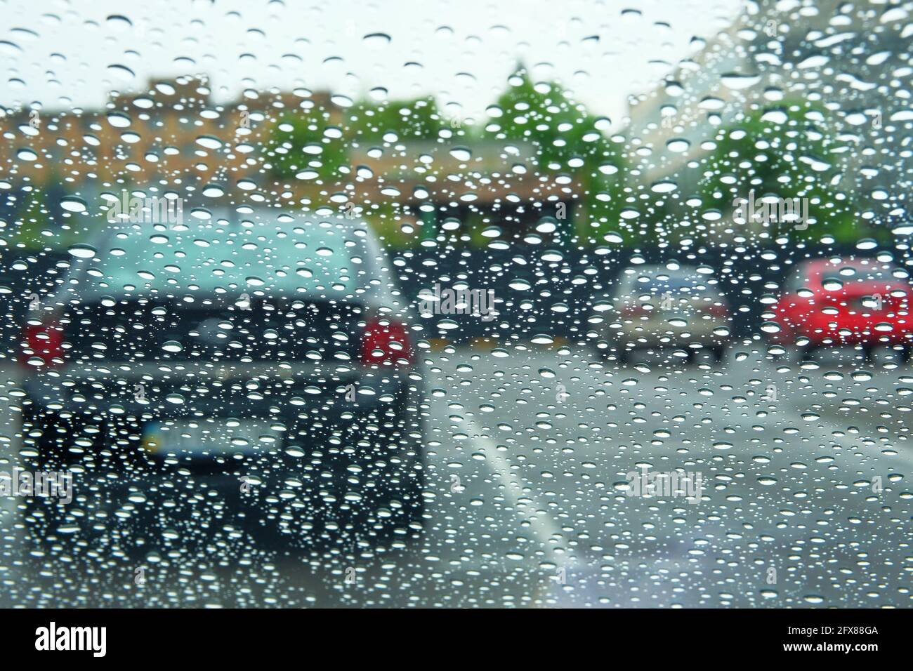 Giorni piovosi. Guida in caso di pioggia, tempo piovoso. La pioggia scende sul finestrino. Foto Stock