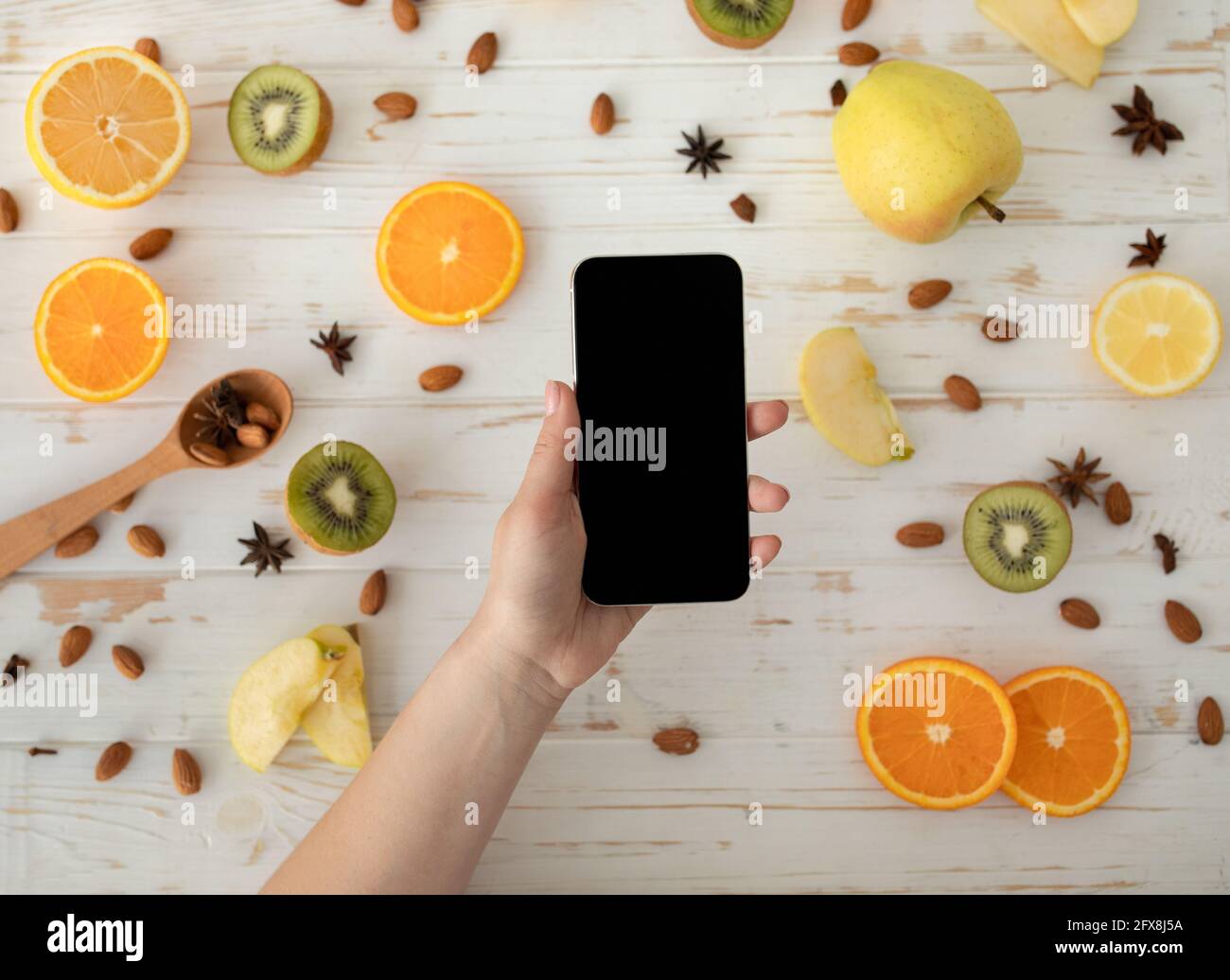 Concetto di dieta. Donna che tiene smartphone con schermo vuoto, mockup per il tuo annuncio, vista dall'alto Foto Stock