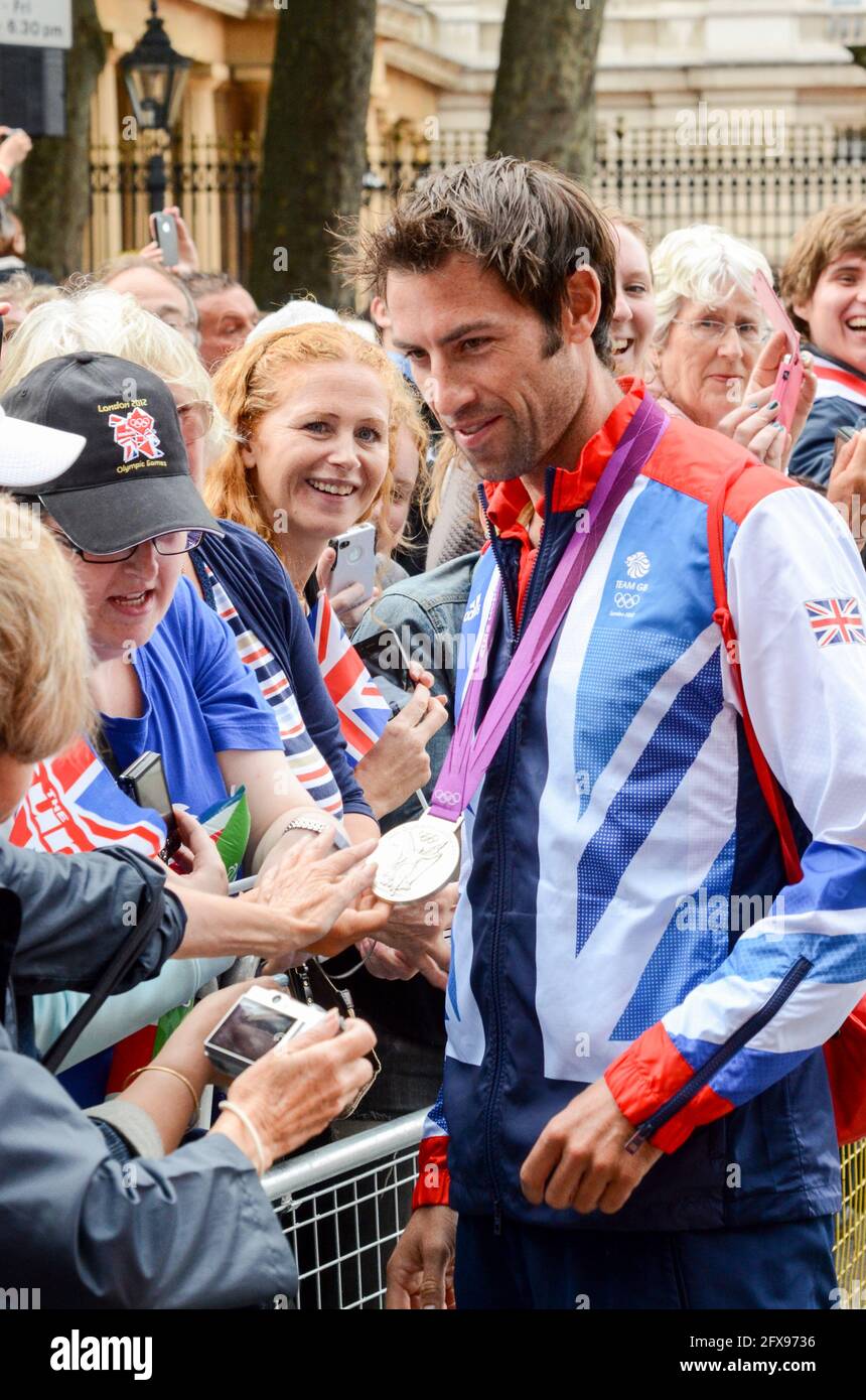 Mark Hunter mostra al pubblico la sua medaglia d'argento canottante come Team GB Olympians lasciando Buckingham Palace dopo la parata della vittoria. Olimpiadi di Londra 2012 Foto Stock