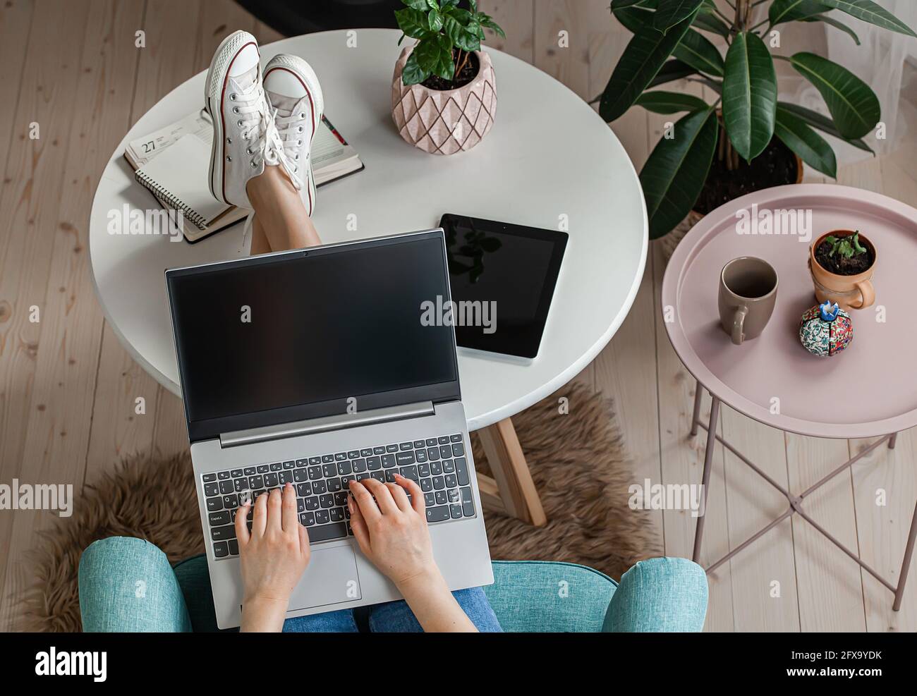 Giovane donna che usa lo schermo del laptop vuoto, mock-up, lavoro a casa, vista dall'alto Foto Stock