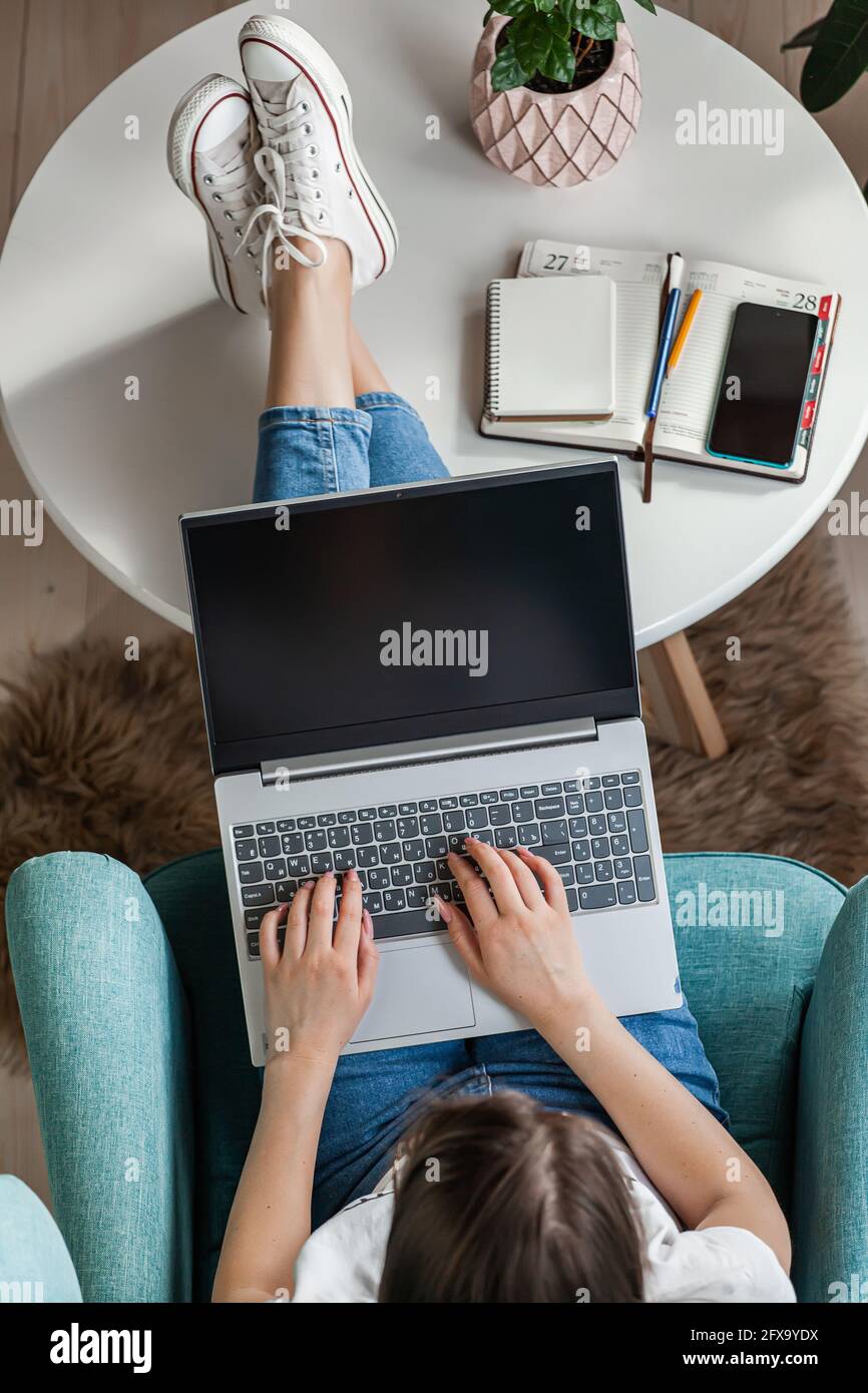 Giovane donna che usa il computer portatile per lavorare a casa, lavorare a distanza Foto Stock