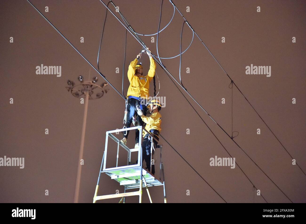 (210526) -- NANNING, 26 maggio 2021 (Xinhua) -- i membri del personale ferroviario sostituiscono le corde sospese del sistema di contatto aereo in una sezione ferroviaria a Nanning, regione autonoma Guangxi Zhuang della Cina meridionale, 26 maggio 2021. Gli oggetti a luce casuale, come i aquiloni rotti, i palloncini galleggianti e le pellicole di plastica che scivolano, rappresentano una minaccia significativa per il funzionamento sicuro delle linee ferroviarie ad alta velocità, che influiscono sull'ordine della rete ferroviaria o causano danni irreversibili alle apparecchiature del sistema di contatto aereo. Il dovere di un gruppo di membri del personale ferroviario è quello di sorvegliare regolarmente i percorsi per pulire Foto Stock