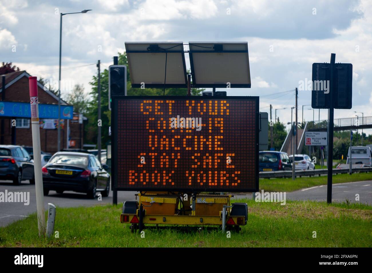 George Green, Buckinghamshire, Regno Unito. 26 Maggio 2021. Un segno LED che ricorda alle persone di prenotare i loro vaccini Covid-19. Il tasso di infezione da rotolamento di sette giorni Covid-19 per 100,000 persone in Slough per la settimana che termina il 18 maggio è salito a 25.4, rispetto a 22.7. Dato che il numero di casi positivi di variante indiana di Covid-19 sta iniziando ad aumentare, la possibile eliminazione di tutte le restrizioni di blocco a giugno potrebbe ora essere in pericolo. Credito: Maureen McLean/Alamy Foto Stock