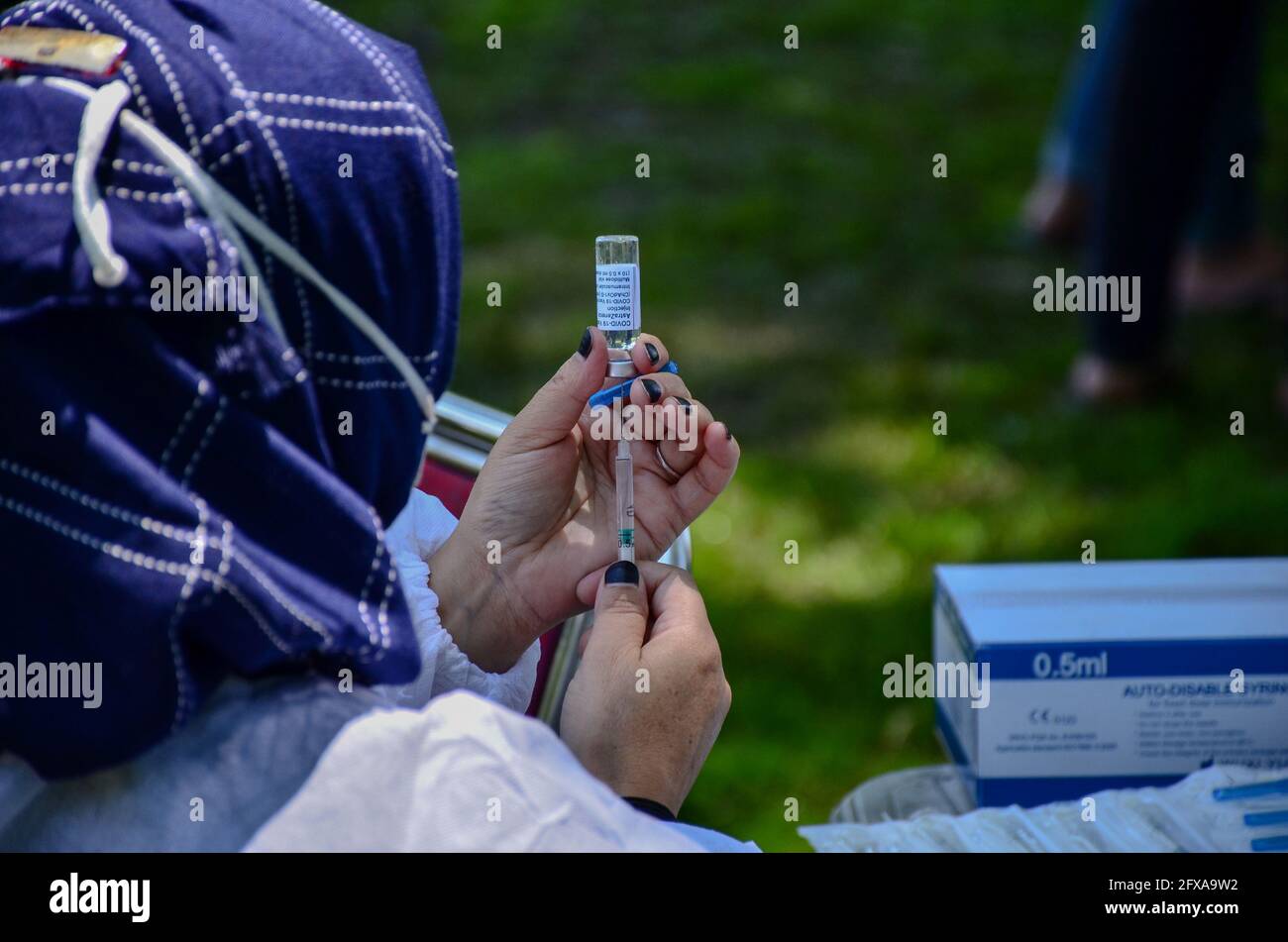 Un operatore sanitario prepara il vaccino Coronavirus Covisield sviluppato dall'Università di Oxford e da AstraZeneca durante il viaggio di vaccinazione in un parco a Srinagar. Il governo ha iniziato martedì un'unità speciale di vaccinazione per la categoria di età 18-44 in Jammu e Kashmir. Martedì 41,423 persone sono state vaccinate, che comprende 20,237 persone della vulnerabile gruppo di 18-44 anni, ha detto un funzionario. Nel frattempo, l'India ha registrato un aumento dei casi giornalieri di Covid-19, in quanto sono state segnalate altre 208,921 infezioni e altre 4,157 morti a causa dell'infezione, spingendo il numero dei decessi a livello nazionale a 311,388. (Foto di Saqib Majeed Foto Stock