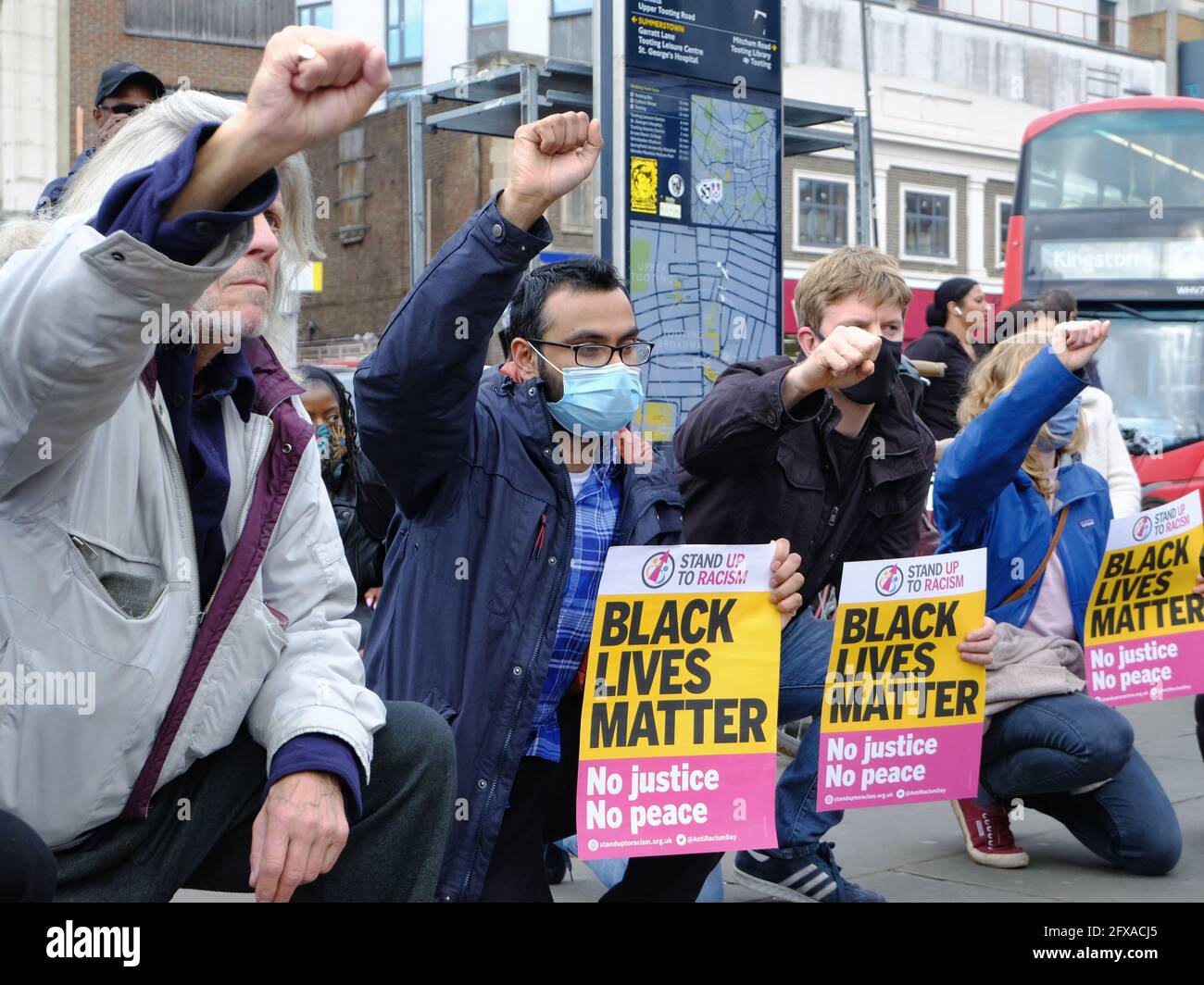 Attivisti anti-razzismo, tra cui i consiglieri locali "take the knee", nel primo anniversario della morte di George Floyd a Toting, Londra del sud. Foto Stock