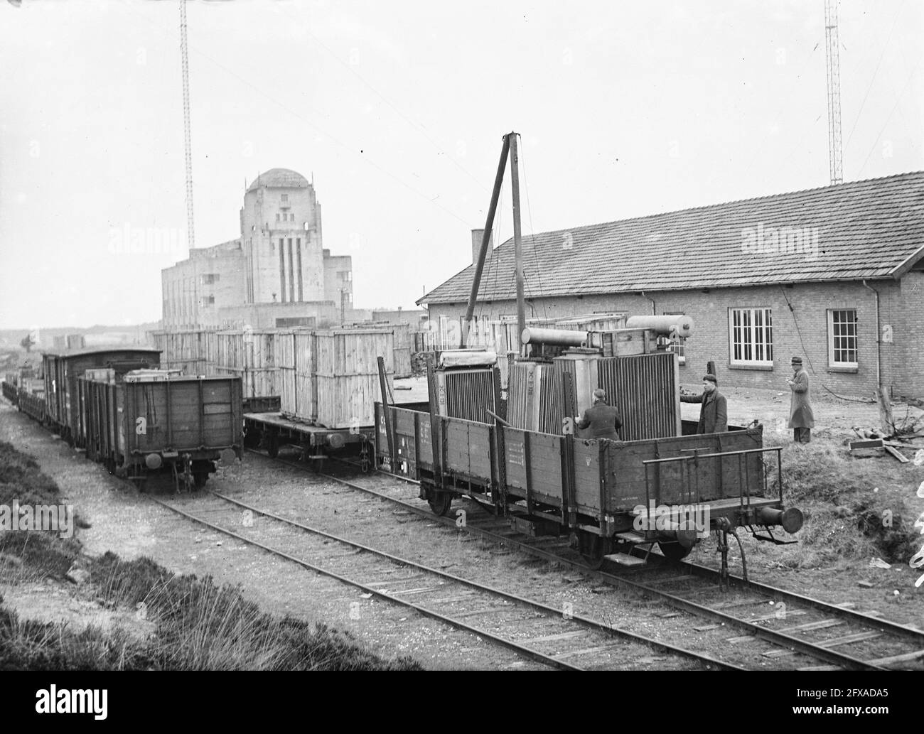 Dalle autorità olandesi, che si occupano del tracciamento dei materiali prelevati dai Paesi Bassi dai tedeschi, nella zona russa della Germania, è stato recuperato l'intero impianto di trasmissione della stazione di Kootwijk. Quattordici carri con materiale sono tornati a Kootwijk oggi. Il sito di scarico per motivi di radio Kootwijk, 3 aprile 1947, radio, riprese, Ferrovie, seconda guerra mondiale, carri, impianti di trasmissione, Paesi Bassi, foto agenzia stampa del xx secolo, notizie da ricordare, documentario, fotografia storica 1945-1990, storie visive, Storia umana del ventesimo Foto Stock