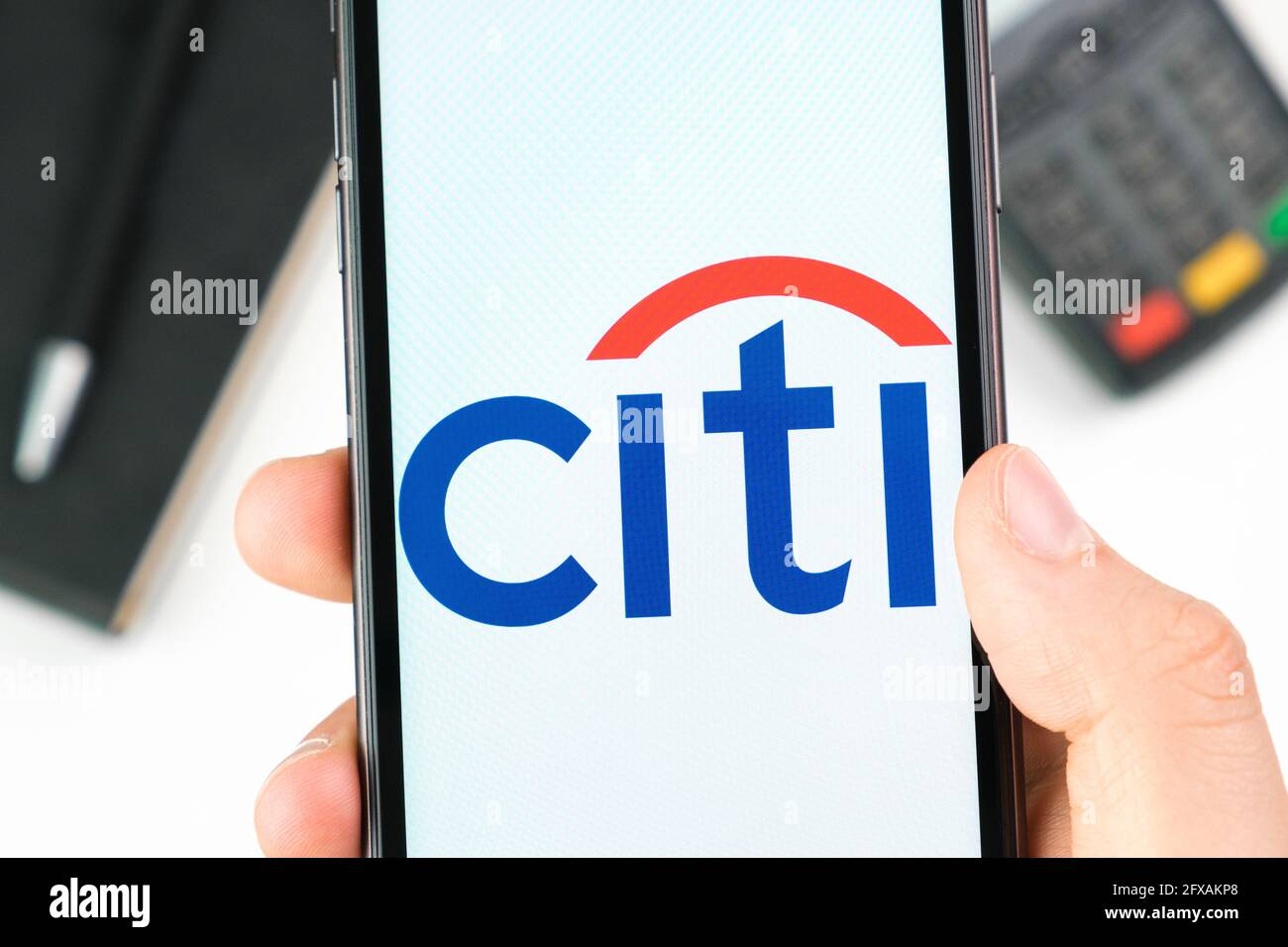 Il logo Citi Bank sullo schermo dello smartphone in mans Hand sullo sfondo del terminale di pagamento, maggio 2021, San Francisco, USA Foto Stock