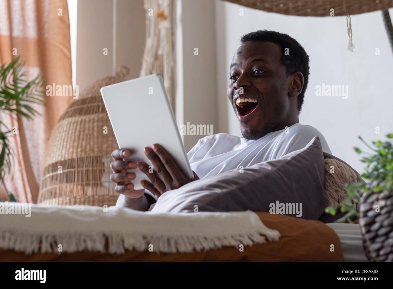 Sorridente uomo web surfing informazioni a casa. Foto Stock