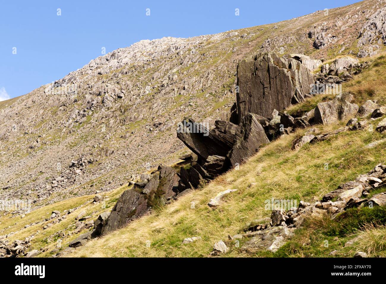 Blocchi di ardesia sulla collina sopra Goat's Water in Cumbria, Inghilterra. L'ardesia è stata precedentemente minata nella zona. Foto Stock
