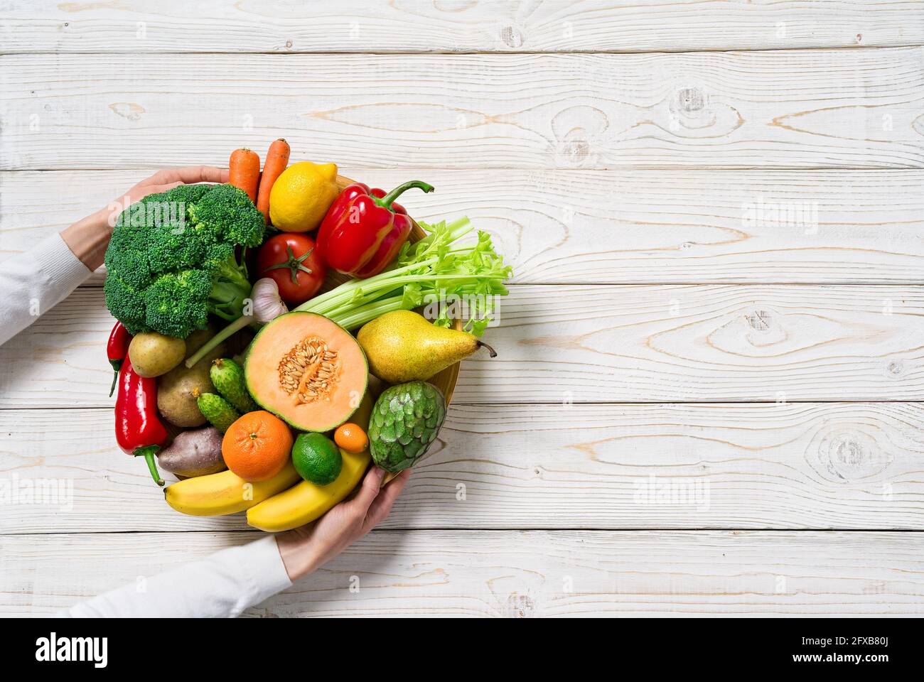 Piatto con verdure e frutta su tavola di legno. Cibo sano, vista dall'alto. Foto Stock