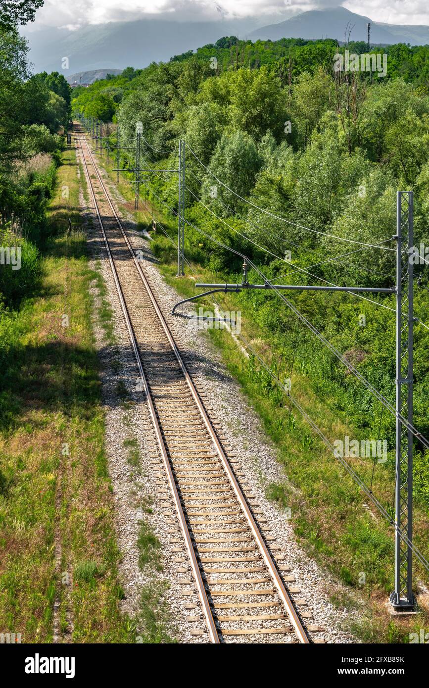 Linea ferroviaria, che attraversa foreste e foreste di montagna, in una calda giornata estiva. Abruzzo, Italia, Europa Foto Stock