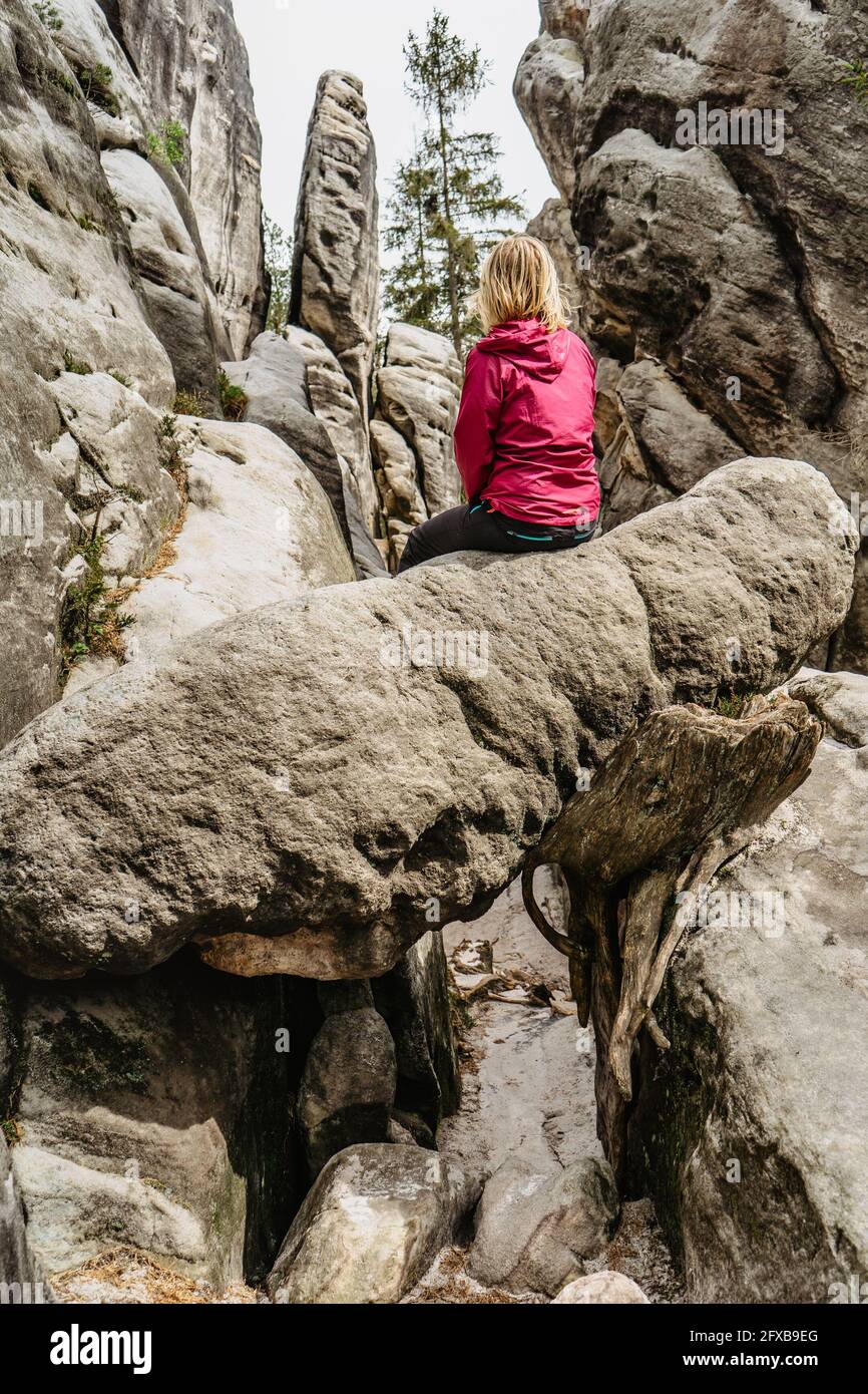 Ostas Riserva Naturale e montagna tavolo, Broumov regione, Repubblica Ceca.seduta ragazza godere vista di rocce, grotte, bizzarre formazioni di arenaria Foto Stock