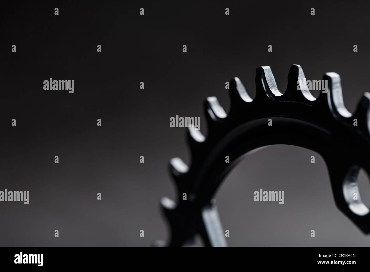 I denti del sistema a stella anteriore della bicicletta su sfondo scuro. Messa a fuoco selettiva Foto Stock