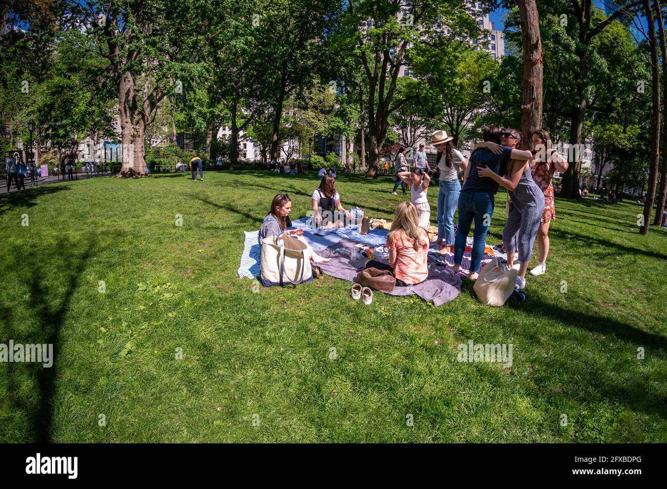 I visitatori del Madison Square Park di New York si rilassano senza maskless tra gli alberi morti dell'installazione della "Foresta fantasma" di Maya Lin venerdì 14 maggio 2021. Il CDC ha pubblicato nuove linee guida che consentono ai completamente vaccinati di partecipare ad attività indoor e outdoor, grandi o piccole, senza indossare una maschera o una distanza sociale. (© Richard B. Levine) Foto Stock