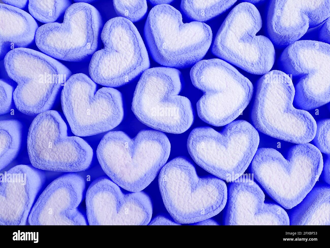 File di caramelle Marshmallow blu pastello e bianche a forma di cuore Per il concetto di Amore Foto Stock