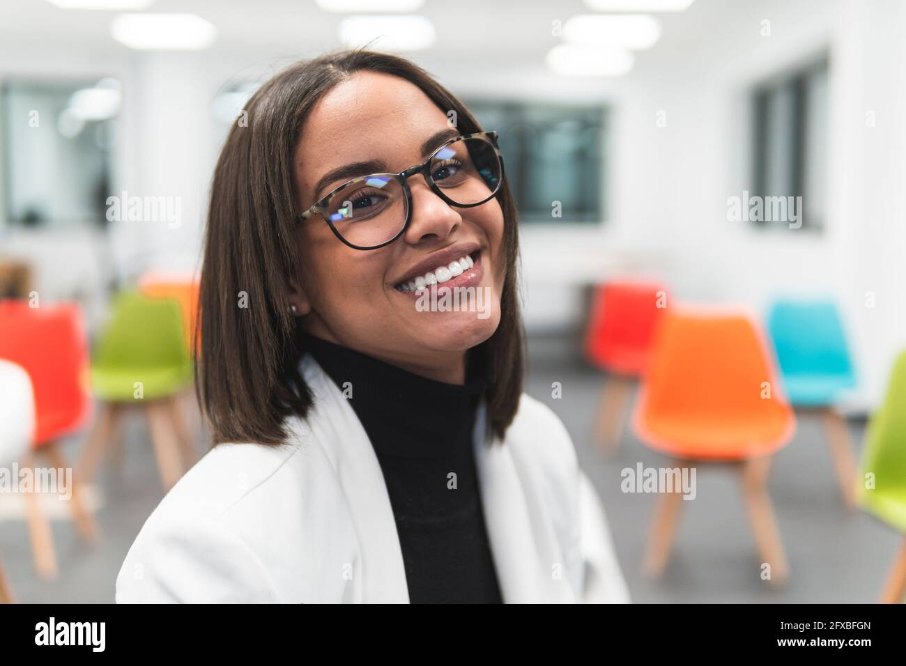 Donna d'affari che indossa occhiali sorridenti in classe Foto Stock