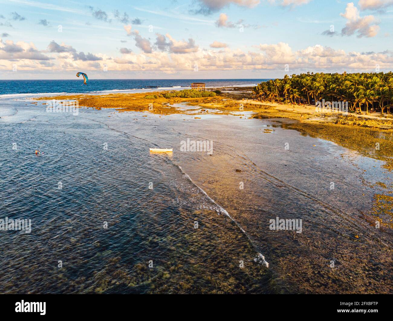 Vista sul drone della costa dell'isola di Siargao con il kitesurfer solista sullo sfondo Foto Stock