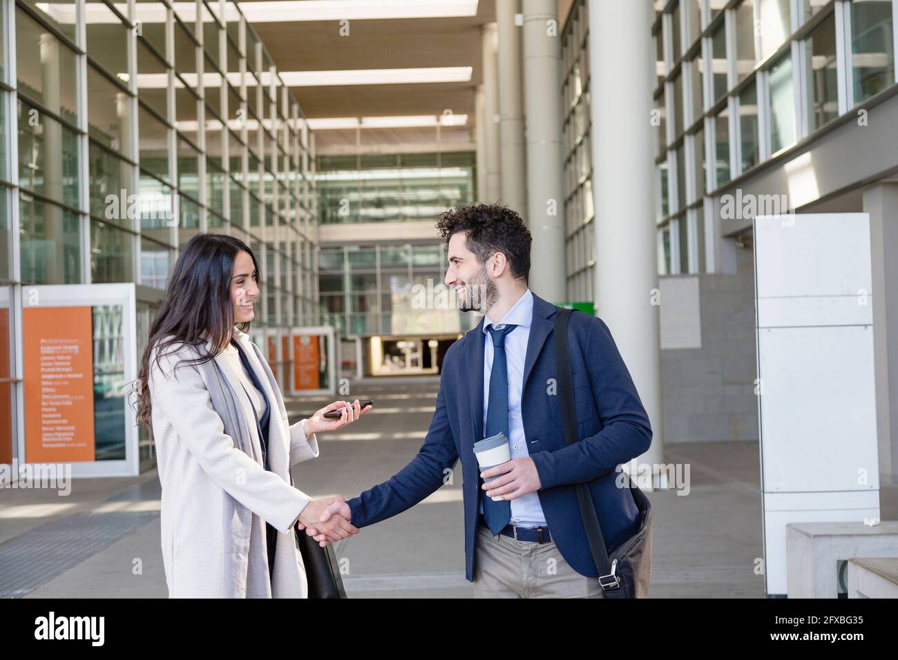 Imprenditori maschili e femminili che fanno stretta di mano mentre si levano in piedi sul sentiero Foto Stock