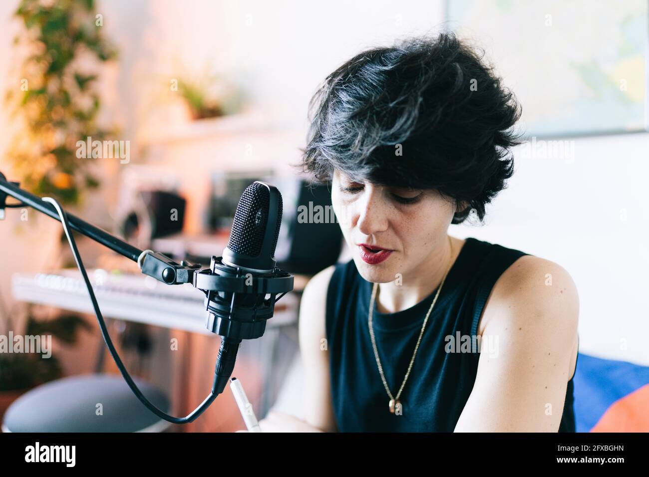 Musicista femminile che canta durante la registrazione in studio Foto Stock