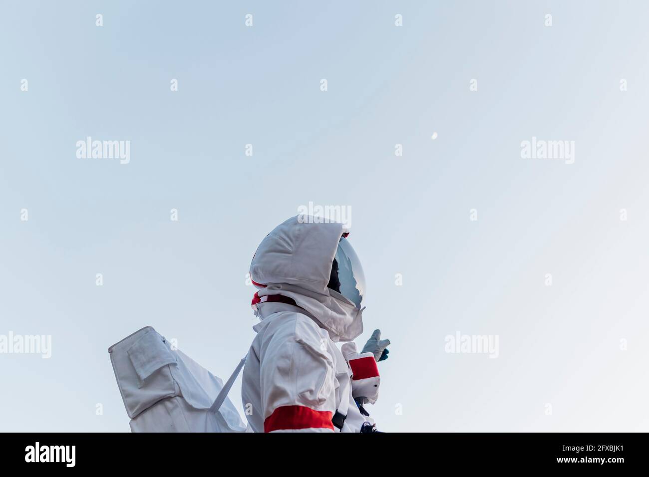 Astronauta maschile in piedi mentre punta verso il cielo Foto Stock