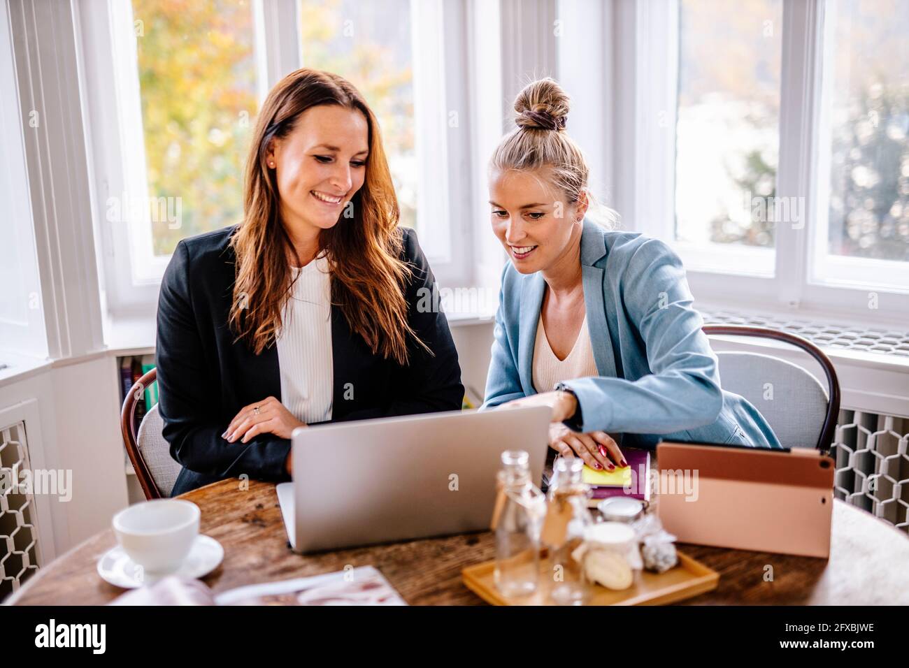 Donne d'affari che discutono sopra il laptop in ufficio Foto Stock