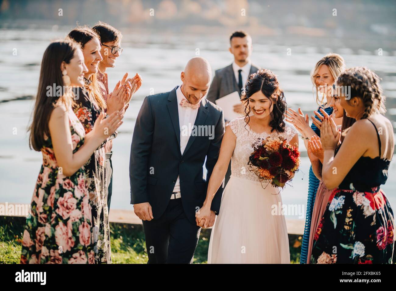 Gli ospiti del matrimonio applaudono per una coppia durante la cerimonia nuziale Foto Stock