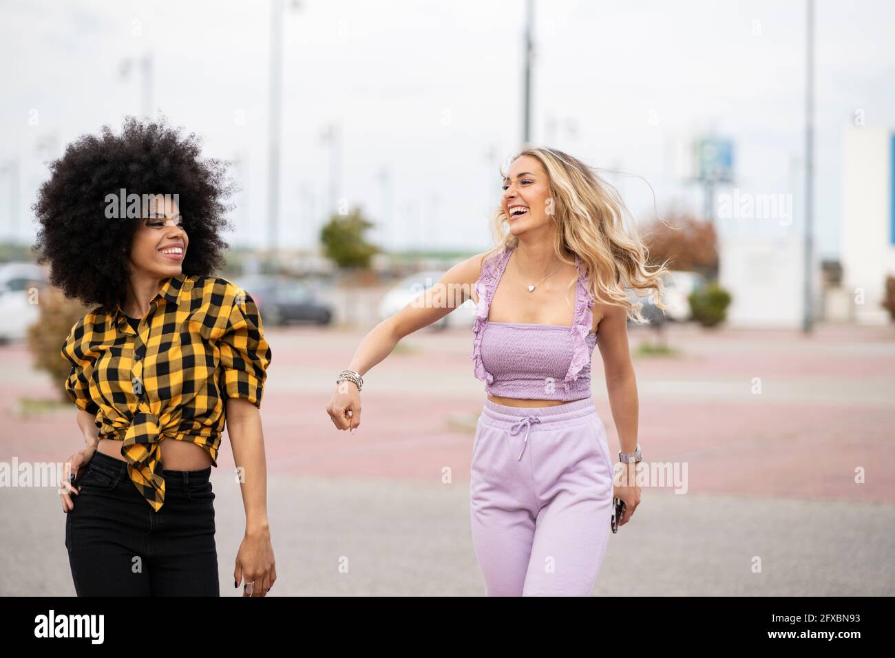 Felici le amiche che camminano in strada all'aperto Foto Stock