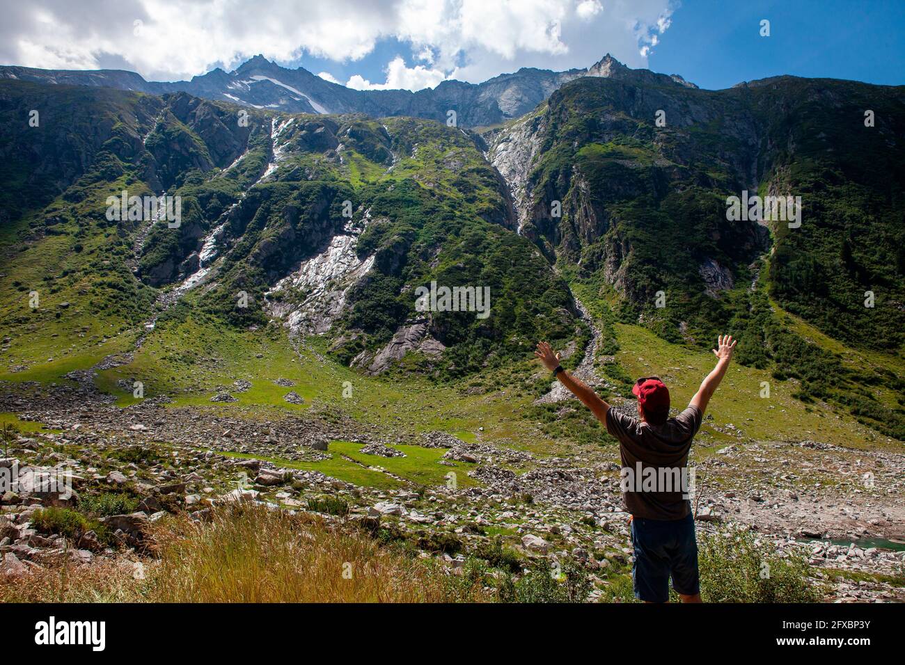 Uomo maturo con braccia alzate in piedi a Zillertal, Austria Foto Stock