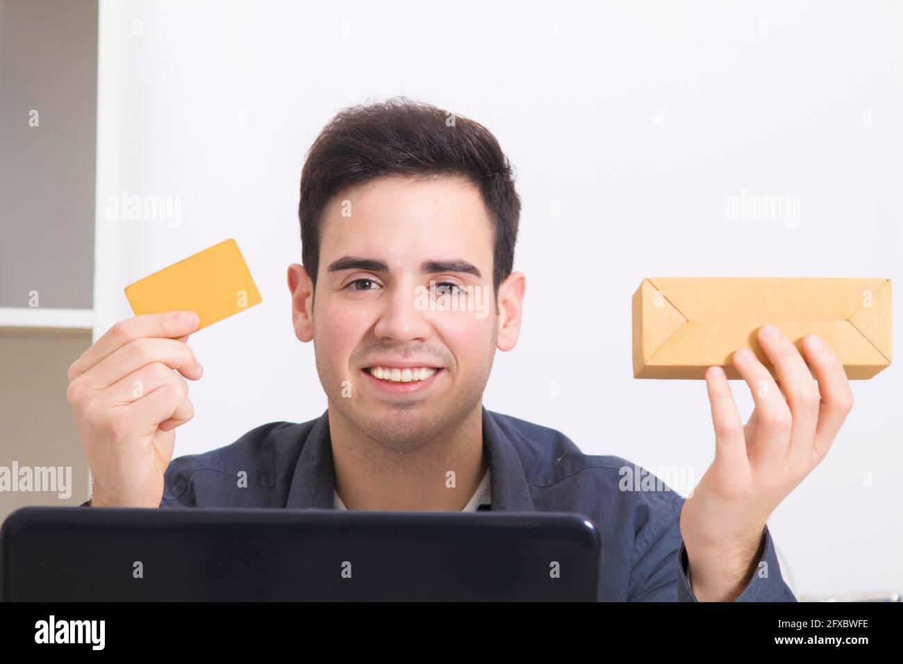 Uomo con carta di credito e computer laptop con box acquisti Foto Stock