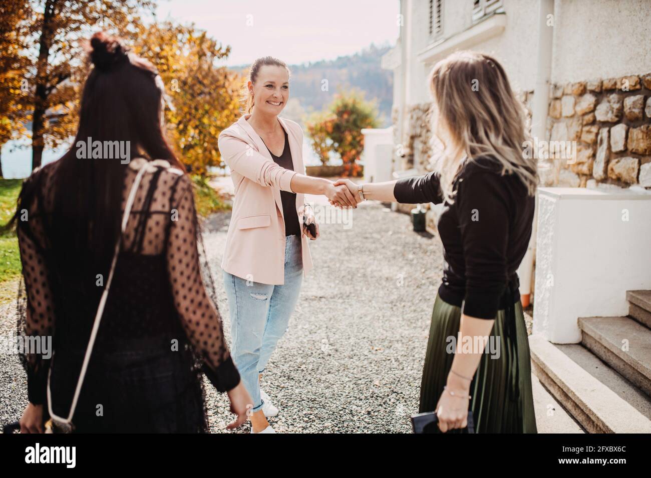 Bella donna che indossa casual elegante facendo stretta di mano Foto Stock