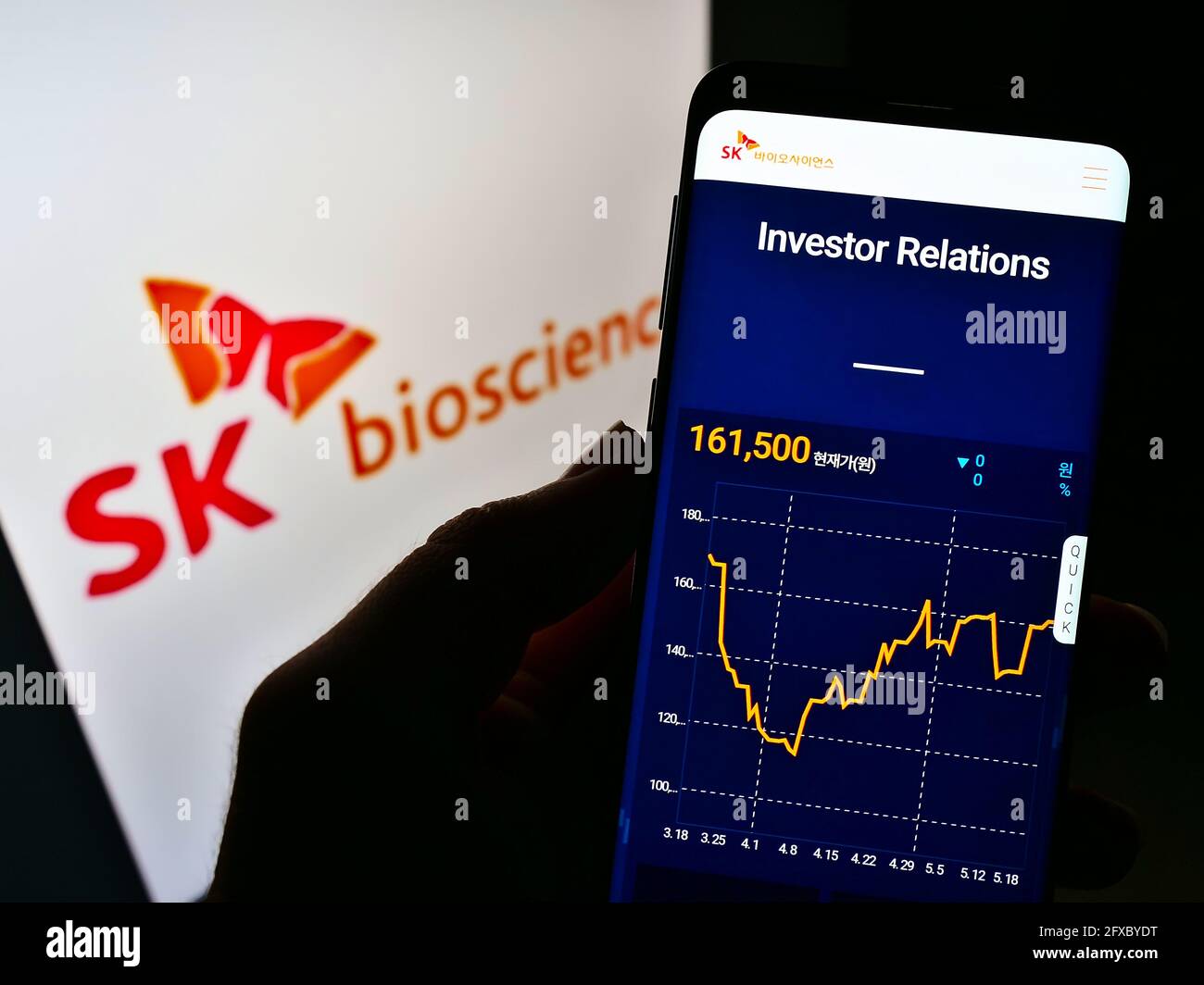 Persona titolare cellulare con pagina web della società biologica sudcoreana SK Bioscience su schermo con logo. Mettere a fuoco il centro del display del telefono. Foto Stock