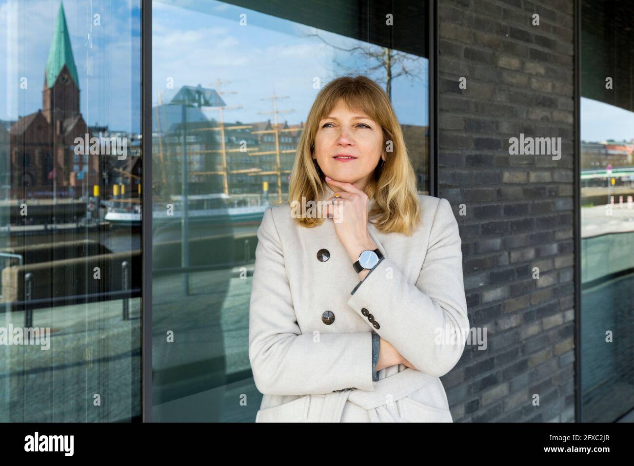 Donna matura con una mano sul mento che guarda via mentre si sta sul sentiero Foto Stock