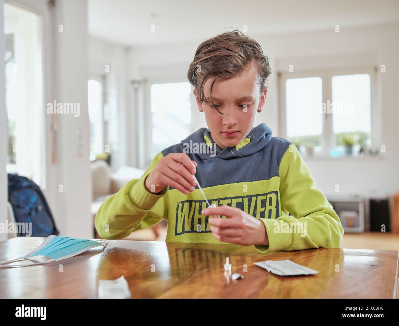 Ragazzo raccolta campione per corona test rapido a casa Foto Stock