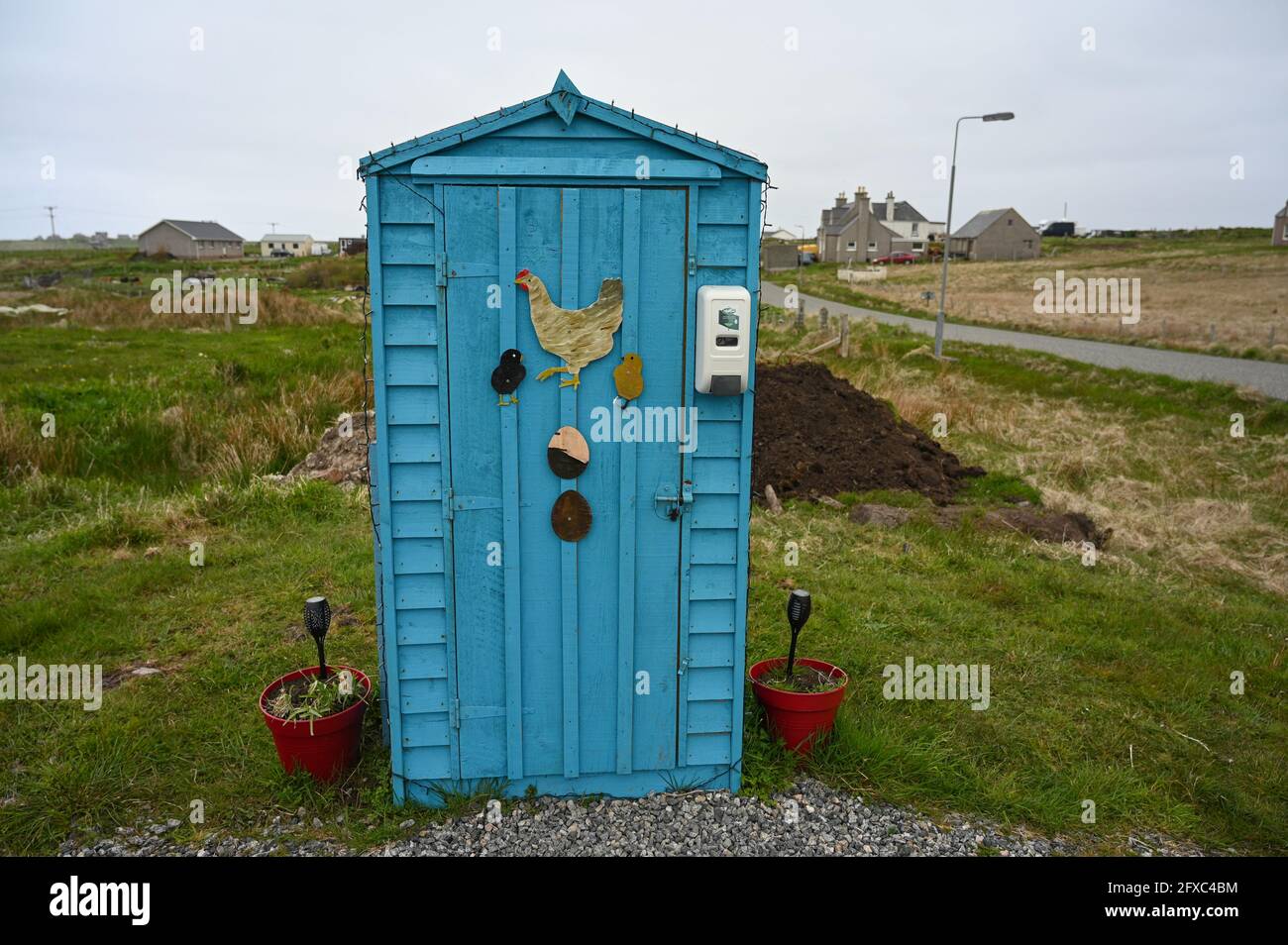 Uova blu in vendita capannone a Habost, Isola di Lewis, Ebridi esterne, Scozia. Opere d'arte di uova e galline all'esterno. Offuscato sfondo rurale e villaggio. Foto Stock