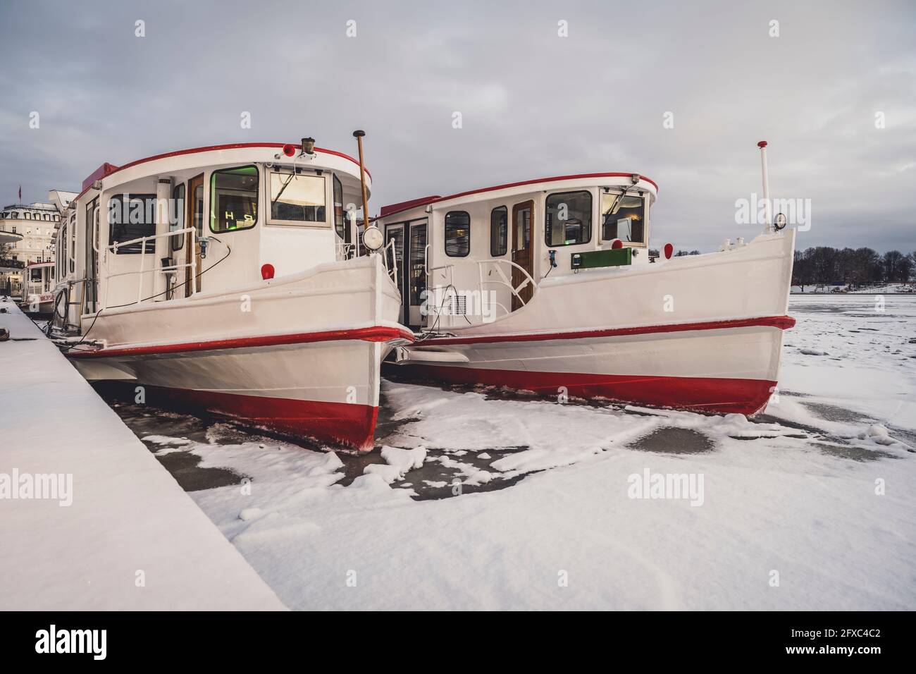 Germania, Amburgo, Passanger navi ormeggiate sul lago ghiacciato di Binnenalster in inverno Foto Stock