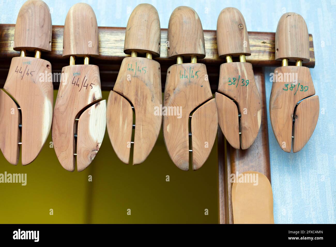 Barelle in legno per calzature appese in officina Foto Stock