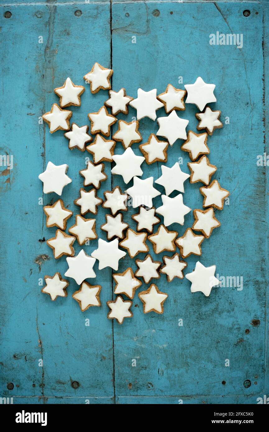 Biscotti a forma di stella alla cannella di Natale su sfondo rustico di legno blu Foto Stock