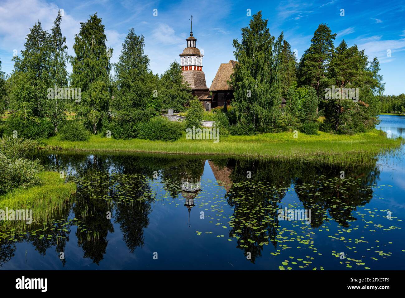 Chiesa di legno che si riflette in lago lucido Foto Stock