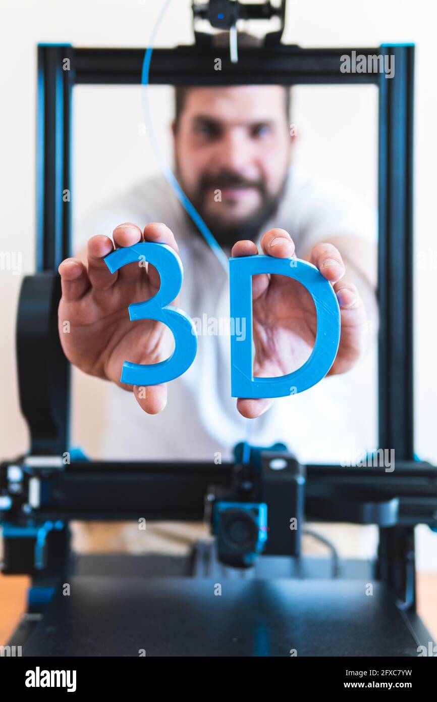 Tecnico maschile con testo stampato in 3D attraverso macchinari Foto Stock