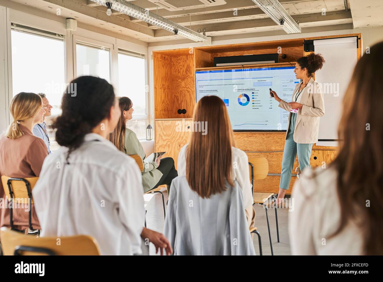 Imprenditrice femminile che spiega il piano aziendale ai colleghi in occasione di un evento educativo Foto Stock