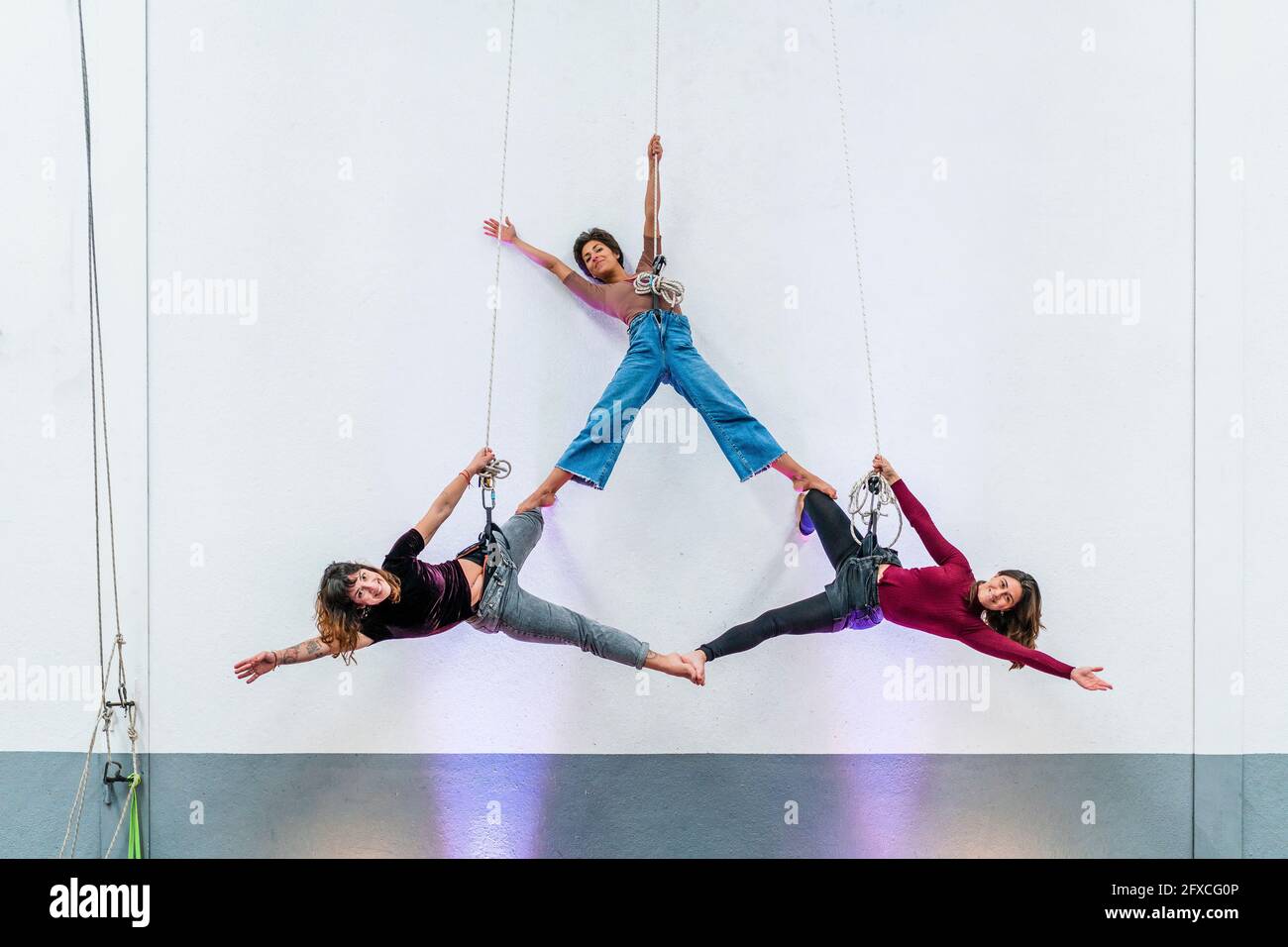 Appassionata ballerina che pratica mentre si appende insieme sulla corda Foto Stock