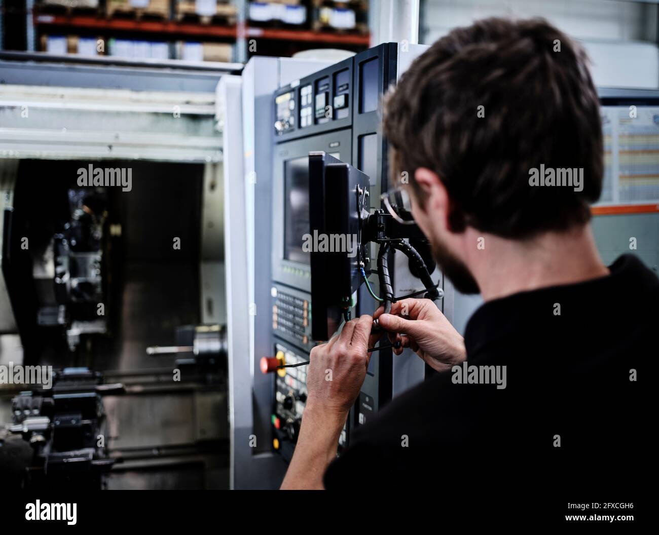 Tecnico che lavora con componenti elettrici nell'industria Foto Stock