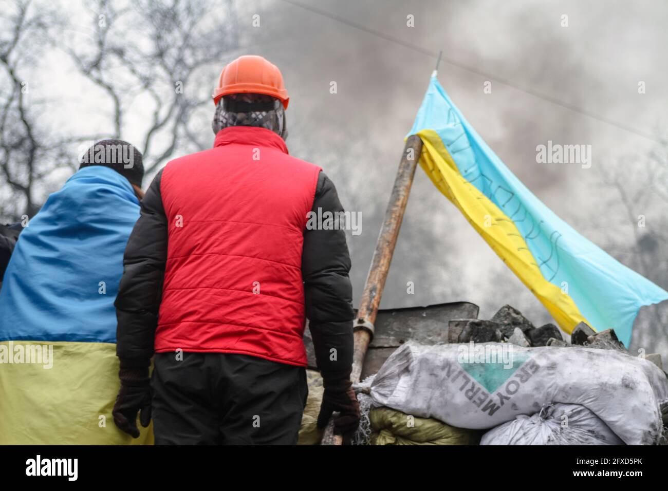 Le spalle della gente sulla strada barricades.Flag di Ucraina durante la lotta per la libertà Foto Stock