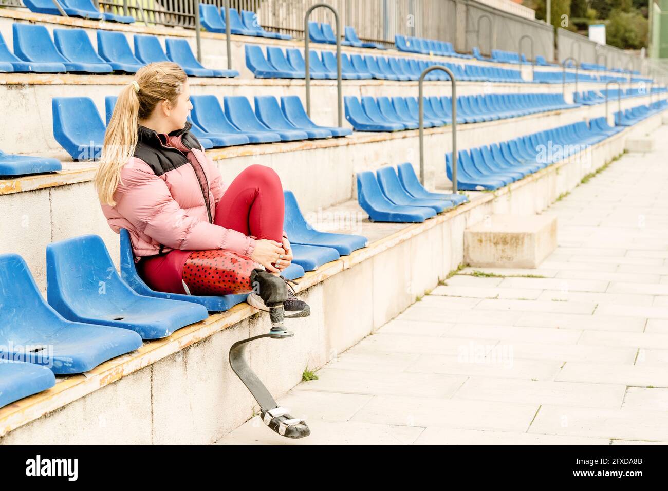 Donna sportiva con disabilità seduta sullo stadio Foto Stock