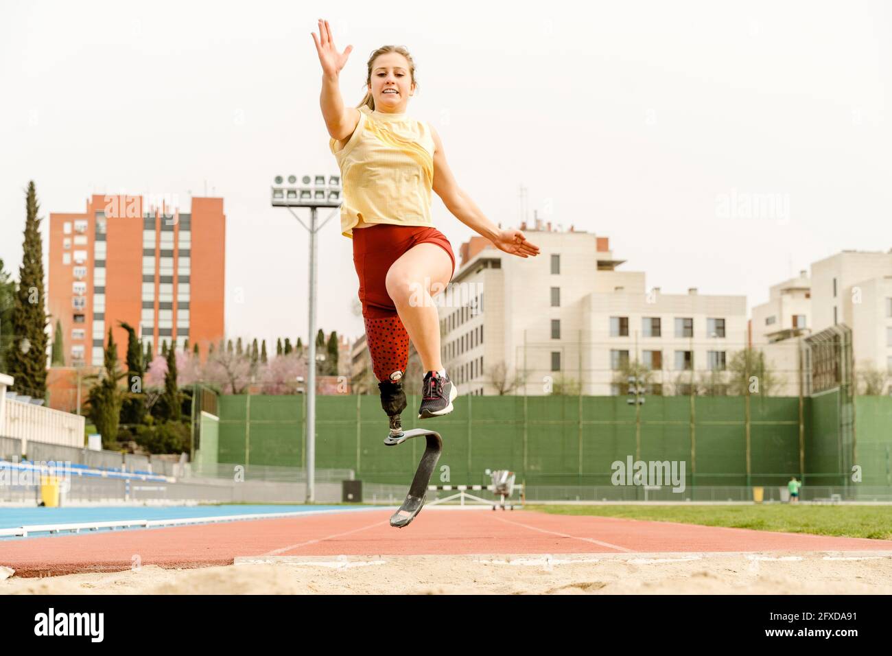 Atleta con disabilità che corre verso il sandpit Foto Stock