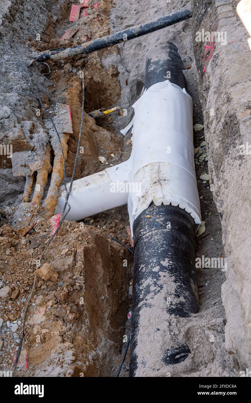 Una canalizzazione di teleriscaldamento posata in tubi di plastica nera in il cantiere Foto Stock
