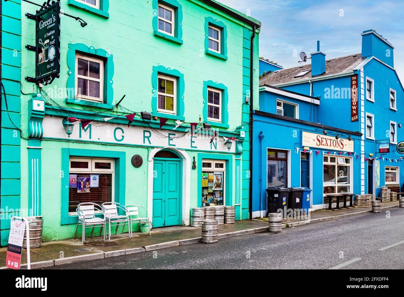 Barili di birra vuoti all'esterno di edifici colorati nel Villaggio di Kinvara sulla baia di Galway nella contea di Galway, Irlanda Foto Stock