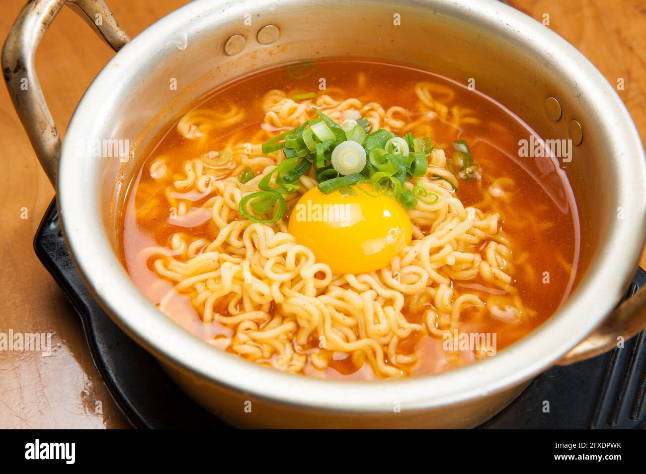 Piccanti noodle kimchi con un tuorlo d'uovo in un ristorante coreano. Foto Stock