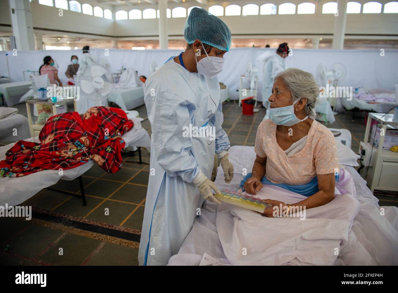 Nuova Delhi, India. 26 Maggio 2021. Un operatore sanitario che indossa una suite di dispositivi di protezione individuale (PPE) ha visto parlare con una donna anziana nello Sri Guru Tegh Bahadar Covid-19 Medical Isolation & Treatment Center, a Gurdwara Rakab Ganj Sahib. Delhi Sikh Gurdwara Management Committee Run covid-19 centro di cura con l'aiuto di Organizzazione Internazionale per i diritti umani e il Governo di Delhi. Il 26 maggio 2021 24, 95,591 casi attivi registrati in India secondo il sito web del Ministero della Salute. (Foto di Pradeep Gaur/SOPA Images/Sipa USA) Credit: Sipa USA/Alamy Live News Foto Stock